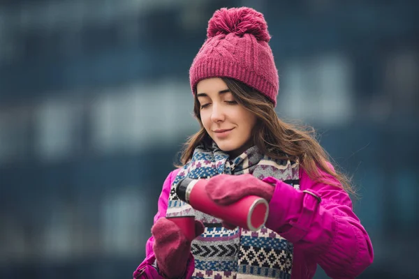 Vrouw in lichte winter jas gieten thee in thermos buiten — Stockfoto
