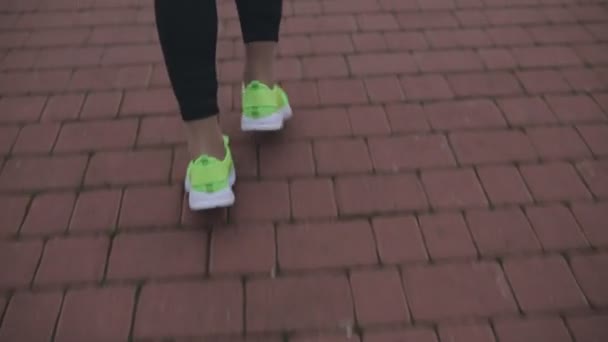 Cultivado de zapatillas de deporte femeninas corriendo en el suelo — Vídeo de stock