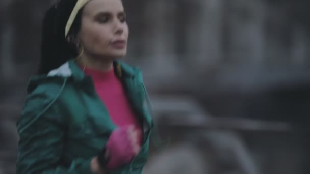 Mujer corriendo al aire libre en el frío día de invierno y mira al paisaje urbano — Vídeos de Stock