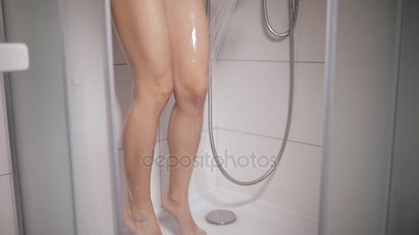 Femme laver ses jambes avec de l'eau dans la cabine de douche — Video