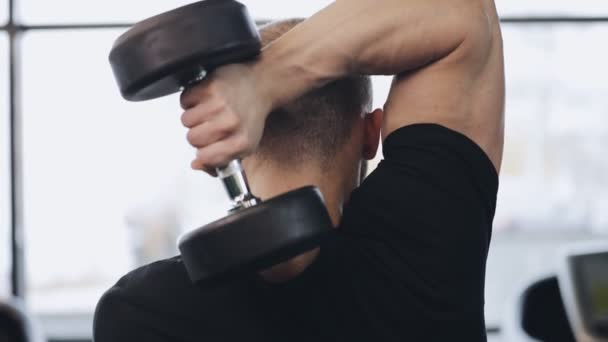 Homem trabalhando com haltere no ginásio, ele bombeando músculos — Vídeo de Stock