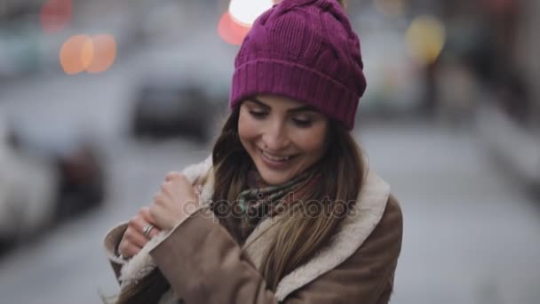 Lachende vrouw weergegeven: tong in een winter-stad — Stockvideo