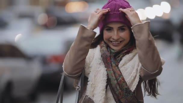 Улыбающаяся женщина, показывающая язык в зимнем городе — стоковое видео