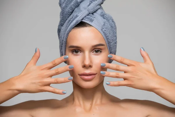 Beautiful spa woman isolated on grey background. She after bath with towel on head. Hands near face. — Stock Photo, Image
