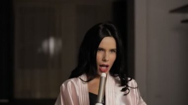 Komik esmer kadın evinde sıcak saç maşası ile çalış