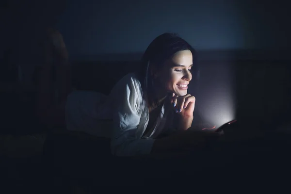 Frau nutzt Bluescreen des Smartphones nachts vor dem Schlafen — Stockfoto
