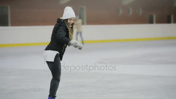 Mulher feliz patinando em uma pista de gelo, férias de inverno — Vídeo de Stock
