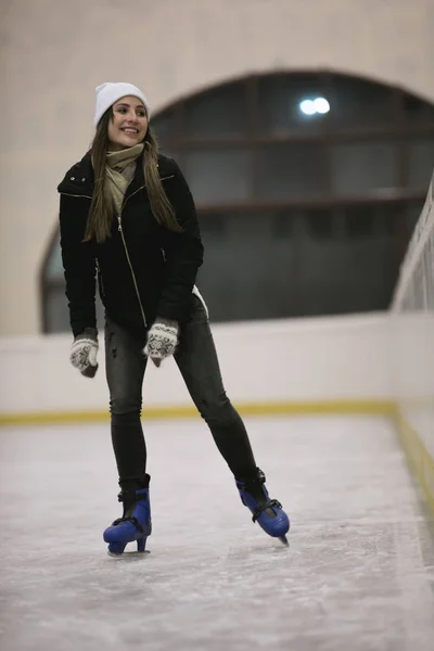 Mulher feliz patinando em uma pista de gelo — Fotografia de Stock