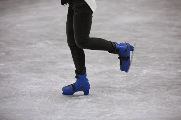 Colpo ritagliato delle gambe della donna che pattinano sulla pista di pattinaggio sul ghiaccio — Foto Stock