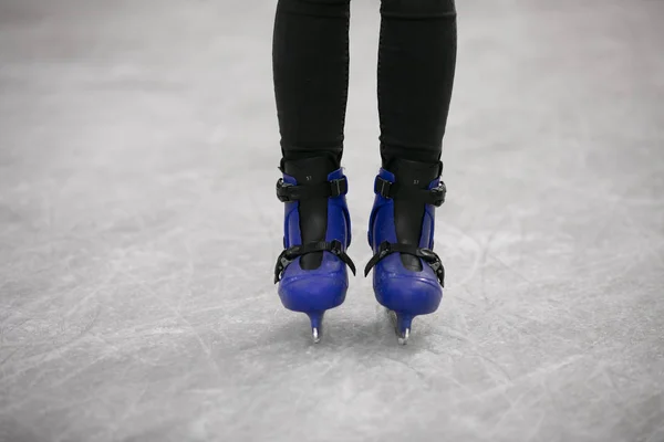 Tiro recortado das pernas da mulher patinando na pista de gelo — Fotografia de Stock