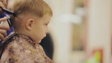 Çocuk saç modeli. Küçük çocuk saç kesimi salonda yakın çekim.