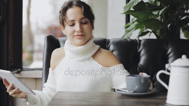 Mujer linda usando tableta PC en un café bebiendo té — Vídeo de stock