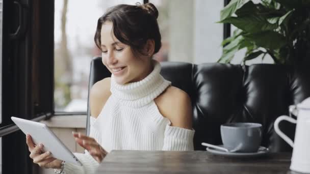 Lachende vrouw met behulp van de tablet Pc in een café het drinken van thee — Stockvideo