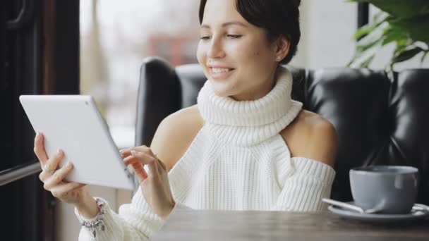 Linda mujer sonriente retrato sosteniendo tableta PC en un café — Vídeo de stock