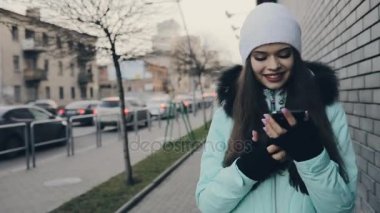 Yürüyüş ve smartphone şehir sokak, o mesajı göndermek kullanarak kız