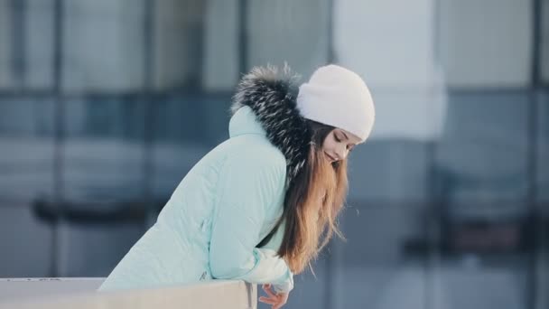 Mujer con sombrero blanco mirando el paisaje de la ciudad en invierno centro — Vídeos de Stock