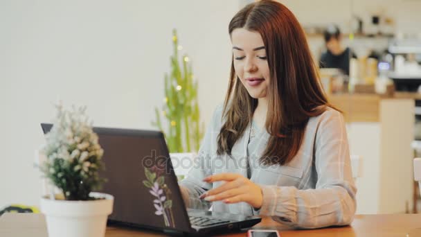 Vrouw blogger werken in café met behulp van een laptop — Stockvideo