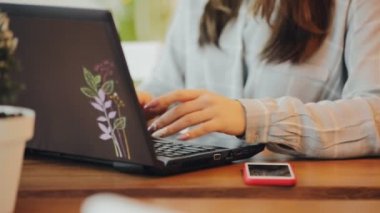 Bir dizüstü bilgisayar kullanarak kafede çalışan kadın blogger