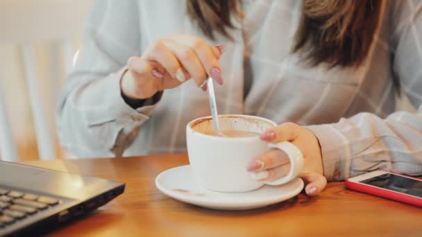 Vrouw geniet drinken koffie in het café, het mengen van suiker — Stockvideo