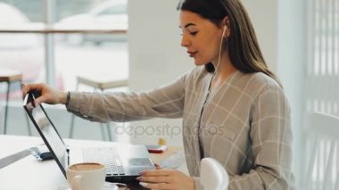 Dizüstü bilgisayar istimal ve müzik dinlemek kafede çalışan kadın blogger