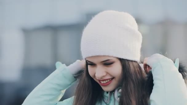 Rolig söt tjej i huva och vit hatt på vintern — Stockvideo