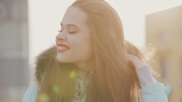 Divertido retrato de chica bonita en sombrero blanco a la luz del sol de invierno — Vídeos de Stock