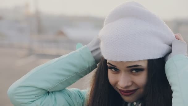 Glad flicka klädd i vit hatt på vinterförvaring utomhus — Stockvideo