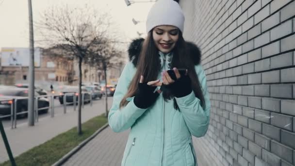 Dziewczyna, chodzenie i przy użyciu smartfona w ulicy, ona Wyślij wiadomość — Wideo stockowe