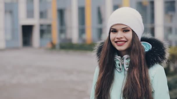 Portret van leuke vrouw in witte winter hoed — Stockvideo