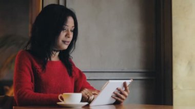 Kafede kahve içme tablet pc kullanan kadın