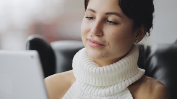 Lachende leuke vrouw met behulp van de tablet Pc in een café — Stockvideo