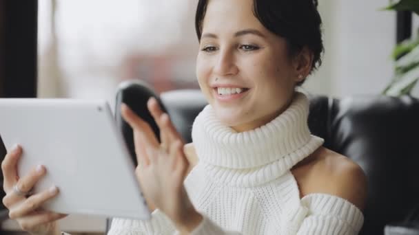 Mujer atractiva sonriente usando tableta PC en un café — Vídeos de Stock