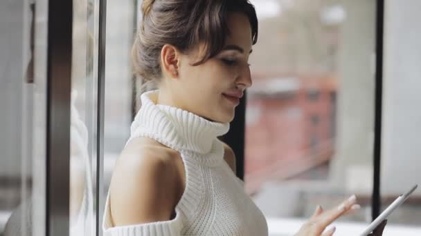 Mujer linda usando tableta PC en un café cerca de la ventana — Vídeo de stock