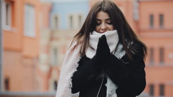 Милая женщина замерзает в морозный день в зимнем европейском городе — стоковое видео