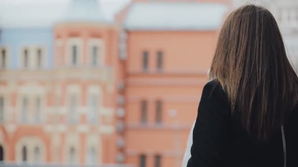 Szczęśliwa kobieta turystycznych Wyświetlono budynku w zimie miasto europejskie — Wideo stockowe