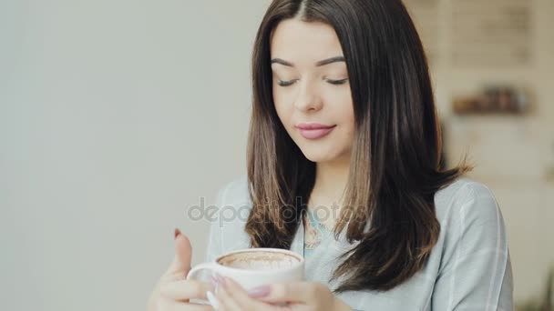 Jovem mulher gosta de beber café no café — Vídeo de Stock