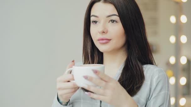 Mujer joven disfrutar de tomar café en la cafetería — Vídeos de Stock