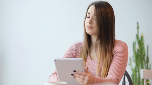 Giovane donna europea utilizzando tablet pc touchscreen in caffè bianco — Video Stock