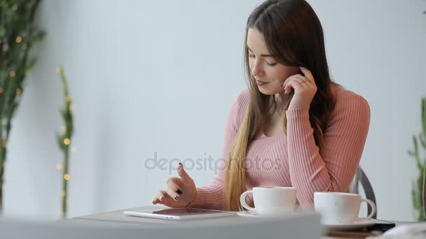 Giovane donna che utilizza tablet pc touchscreen seduto nel caffè bianco — Video Stock