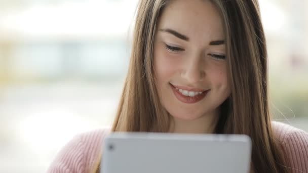 Jovem mulher europeia usando tablet pc touchscreen na janela — Vídeo de Stock