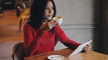 Kafede kahve içme tablet pc kullanan kadın