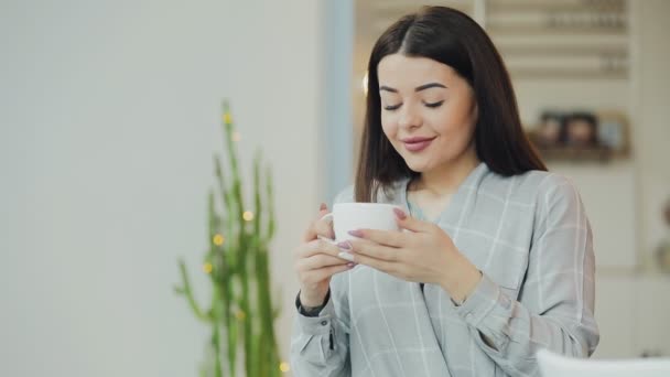 Jonge vrouw geniet van koffie drinken in café — Stockvideo