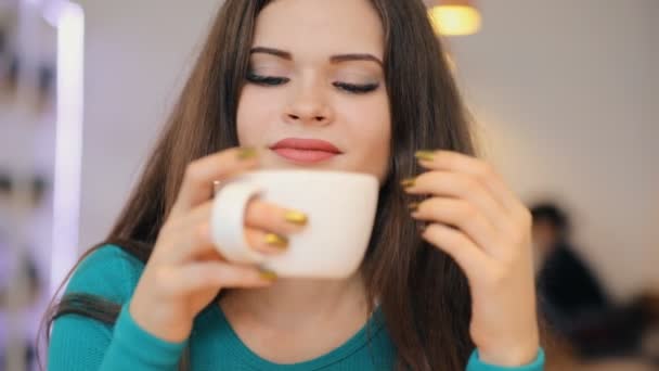 Vrouw genieten van drinken bedrijf koffiekopje zitten in Cafe — Stockvideo