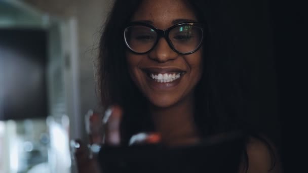 Vrouw in brillen met behulp van touchscreen smartphone op donkere huis corridor — Stockvideo