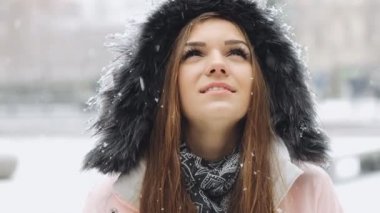 Portre kadar düşen kar için arayan mutlu genç kadın kapatmak