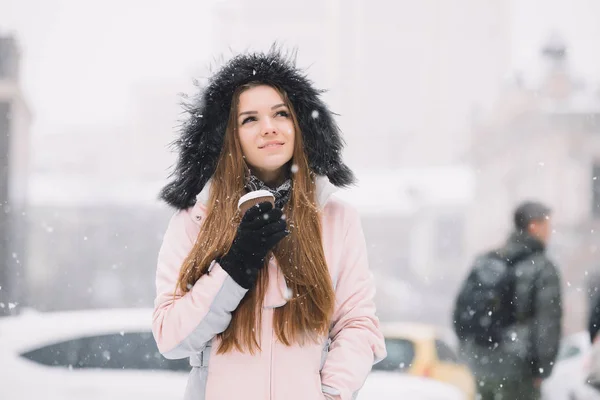 Mujer disfrutando de la taza de café caminando en invierno ciudad nevada —  Fotos de Stock