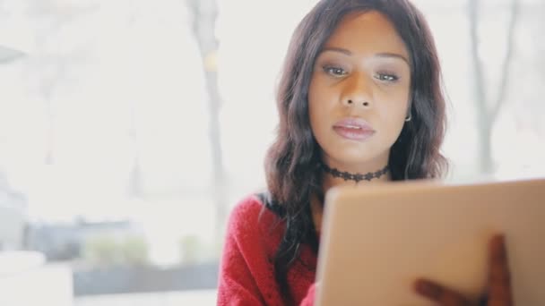 Frau benutzt Tablet-PC vor hellem Fensterhintergrund — Stockvideo