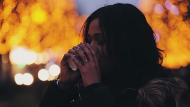 Mulher multirracial bonita bebendo chá na cidade da noite — Vídeo de Stock