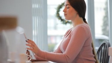 Tablet pc dokunmatik ekran beyaz kafede kullanan genç Avrupa kadın