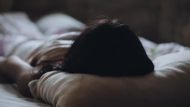 Femme se réveille le matin couchée sur le lit, vue arrière — Video